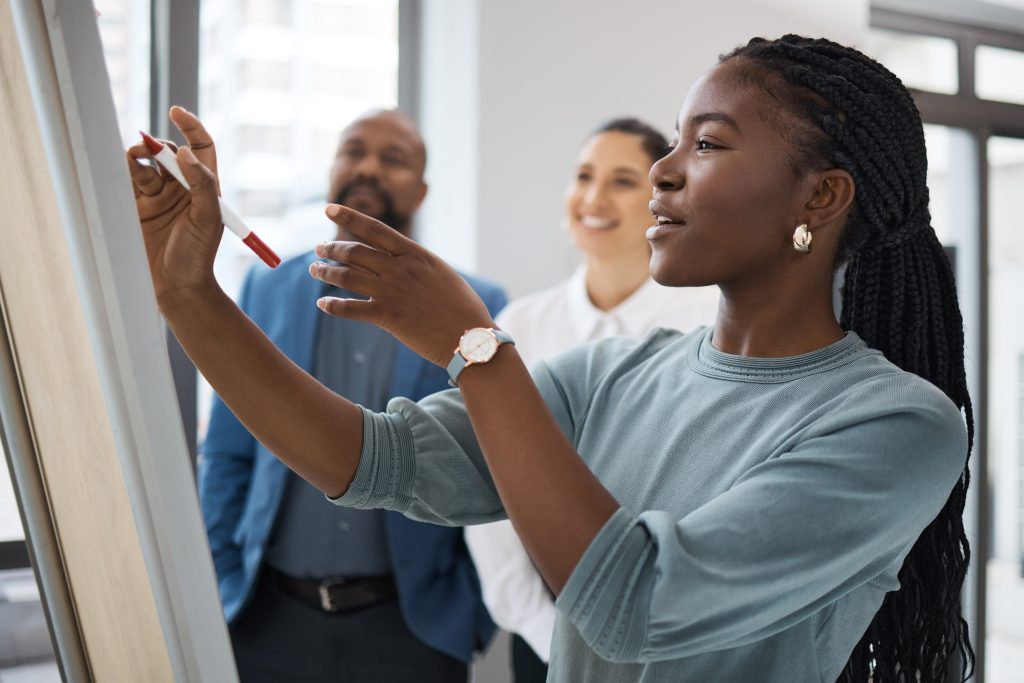 Business woman writing on a whiteboard for company planning with strategy.