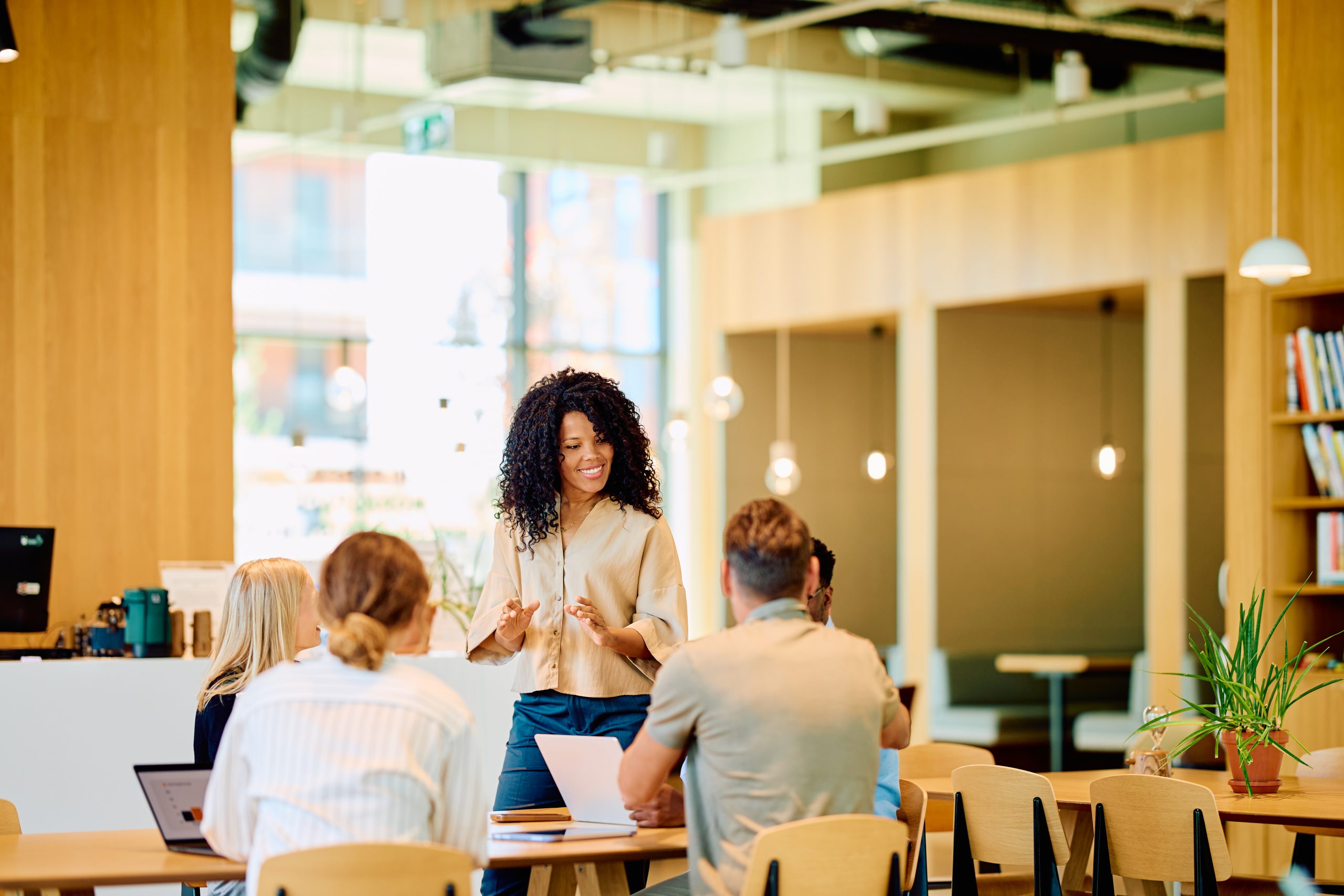 Black woman leading an executive business team meeting in modern office